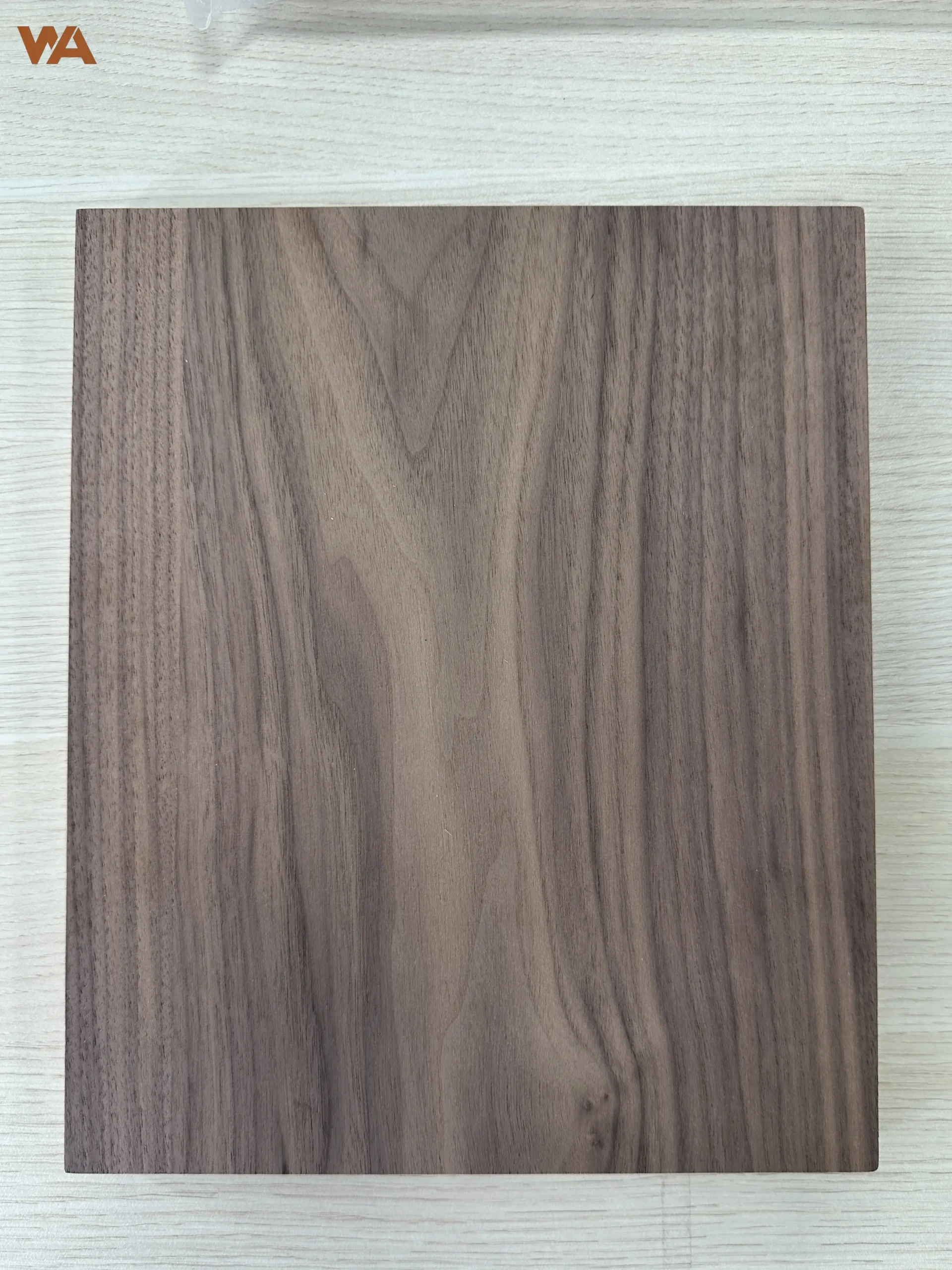 Close-up detail of black walnut plywood surface showing natural wood grain and veneer texture.