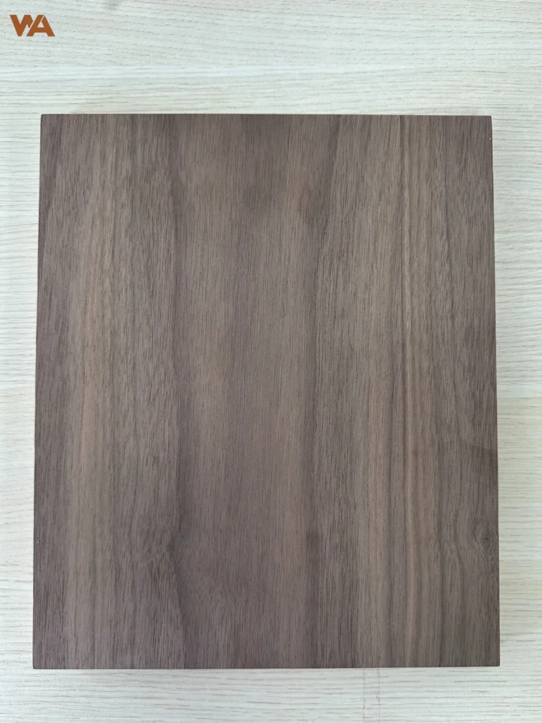 Close-up detail of black walnut plywood surface showing natural wood grain and veneer texture.