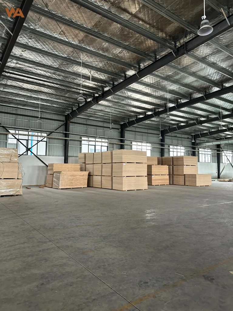 Importer's Guide: How to Calculate Plywood CBM and 40HQ Container Plywood Loading Capacity 4 Rows of bulk commercial plywood panels stacked neatly on heavy-duty wooden pallets inside a large distribution warehouse.