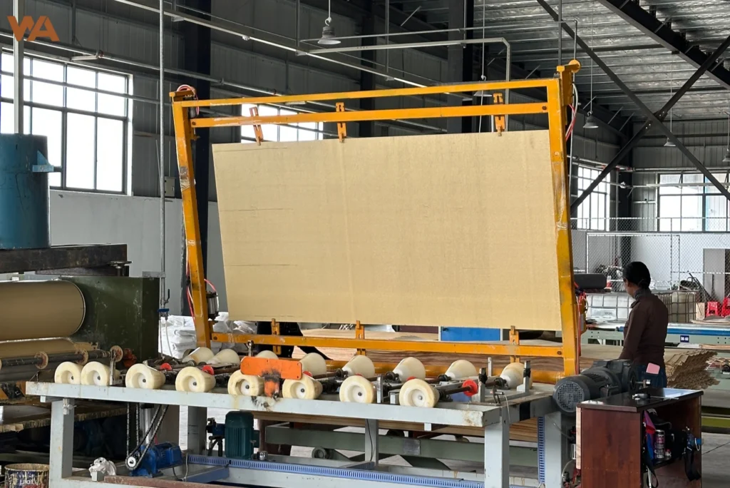 How to Choose a Reliable Plywood Supplier: 5 Core Metrics for B2B Buyers 5 The automated lamination machine applying decorative veneer to plywood panels in a modern manufacturing facility.