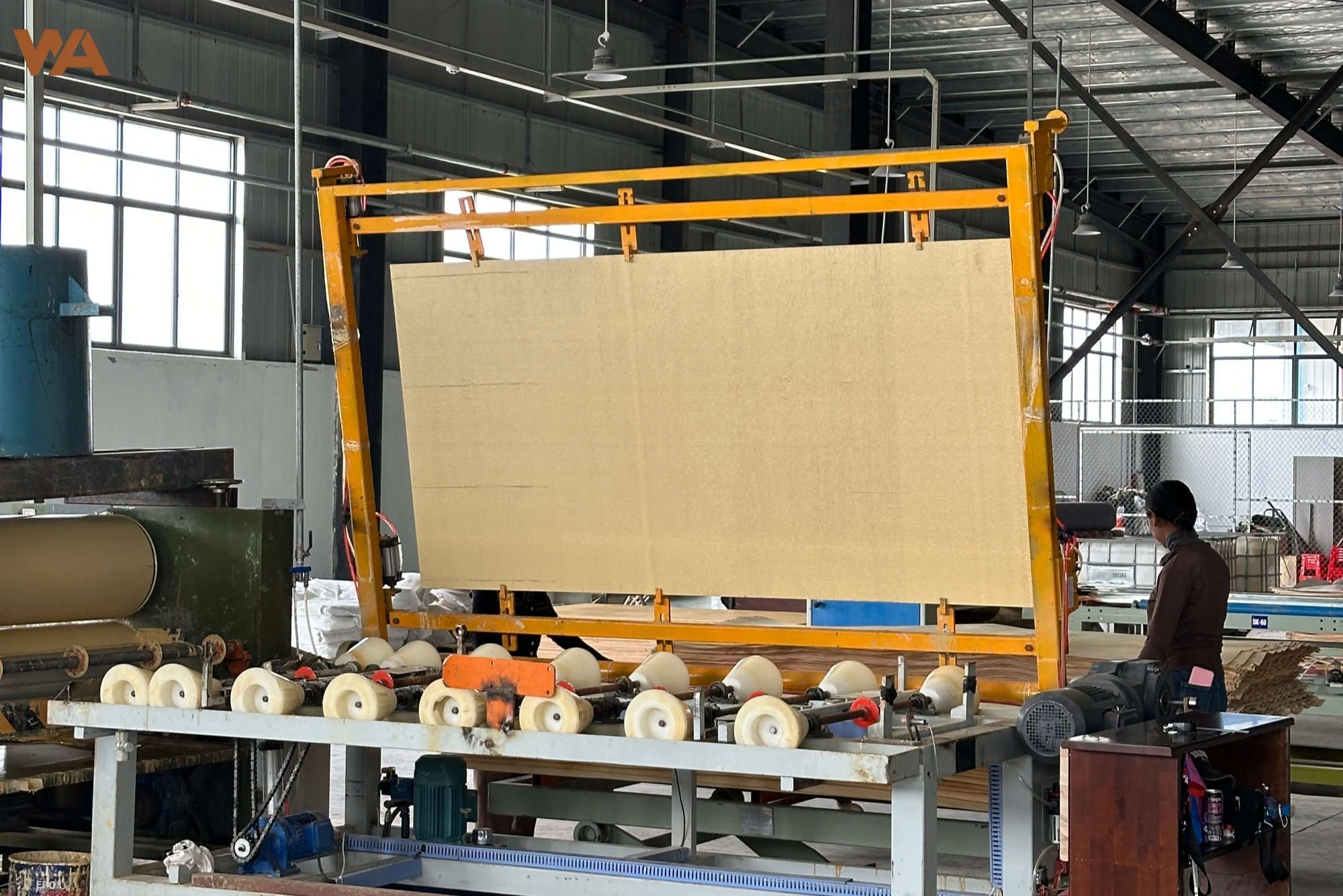 Blog 5 The automated lamination machine applying decorative veneer to plywood panels in a modern manufacturing facility.