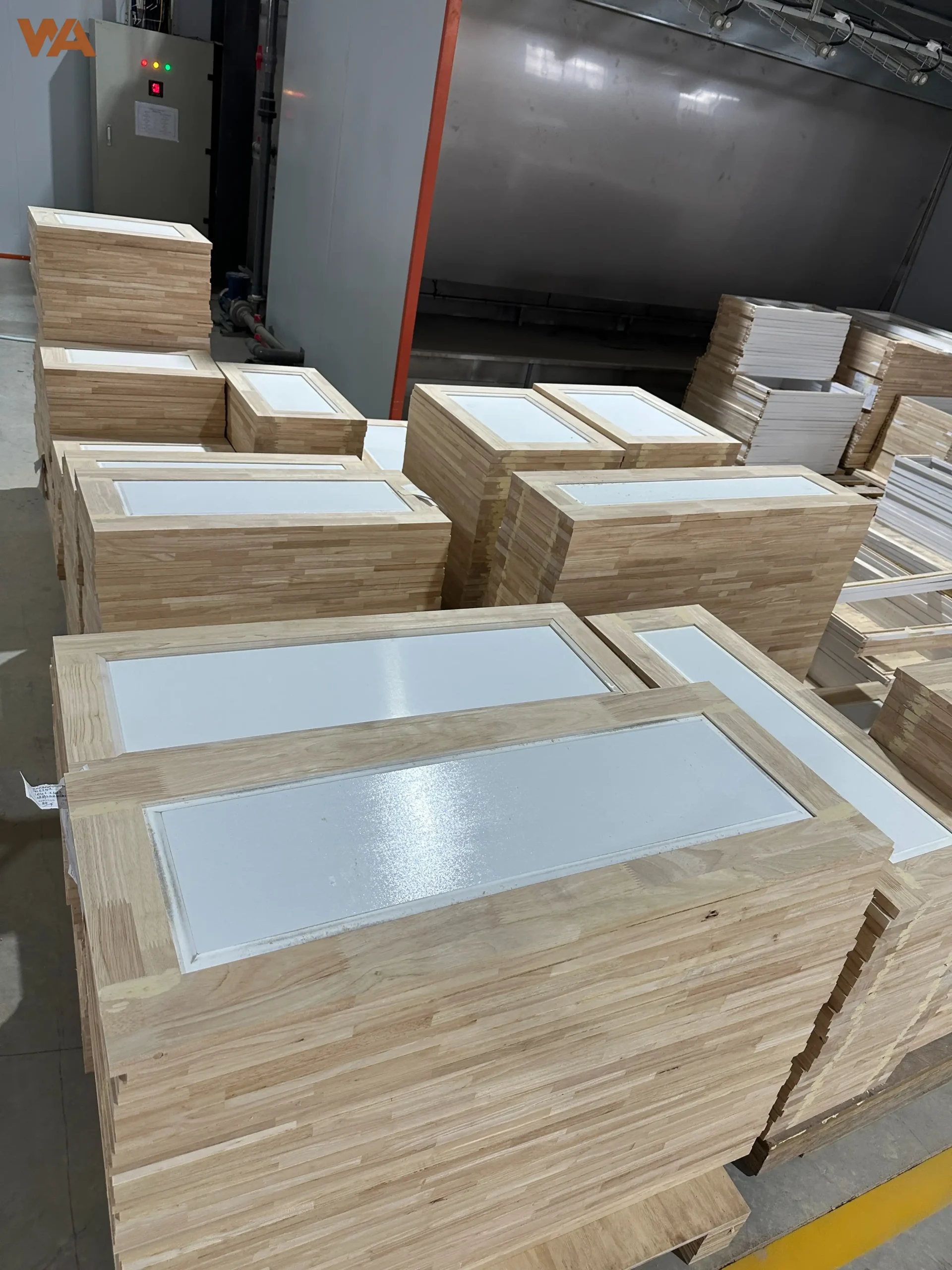 Properly stacking cabinet doors vertically on a wooden drying rack in a furniture factory to prevent warping