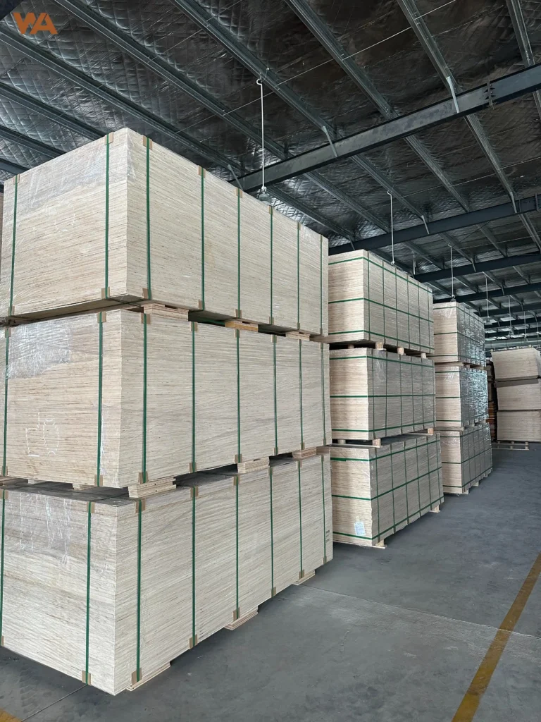 Neatly stacked bundles of high-quality plywood sheets stored in a modern manufacturing factory warehouse.